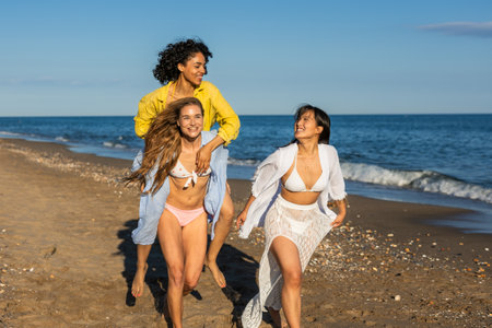 Multiethnic girls running and having fun on the beachの写真素材