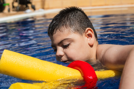 Child with cerebral palsy enjoying pool timeの写真素材