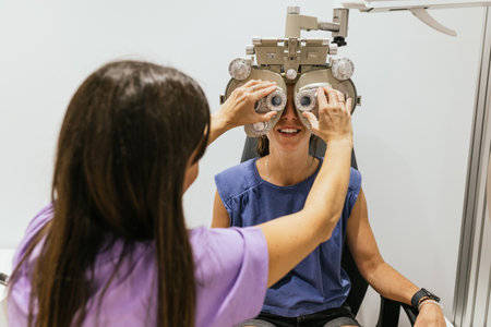 Optometrist adjusting phoropter for eye examination