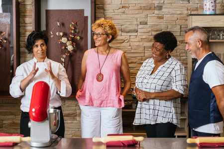 Chef teaching cooking class to diverse group of seniorsの写真素材