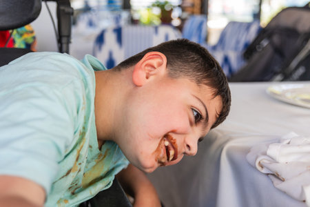 Child with cerebral palsy enjoying a meal at restaurantの写真素材