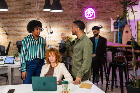 Marketing team discussing new project on laptop in modern officeの写真素材