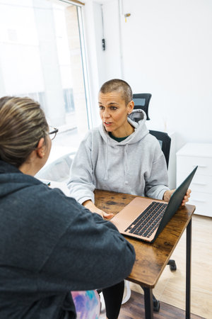 Nutritionist giving advice to client using laptop in office