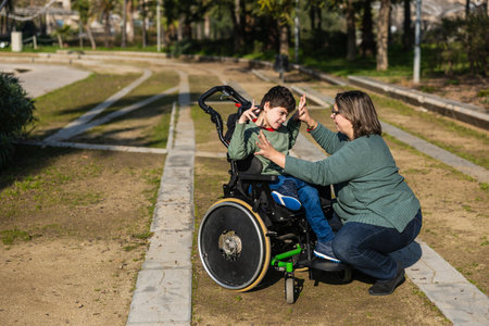 Mother playing with son with disability in wheelchair at park
