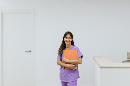 Female optometrist standing holding a clipboard in her hands