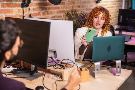 Office workers making video call on mobile phone in coworking space