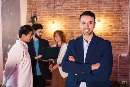 Confident businessman smiling with coworkers working in background