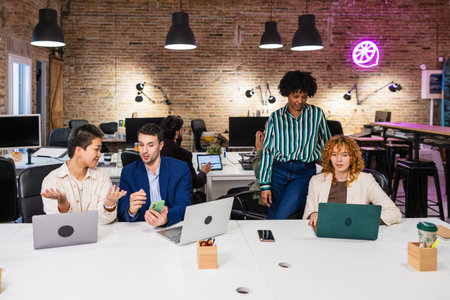 Multi ethnic team collaborating on project in modern office
