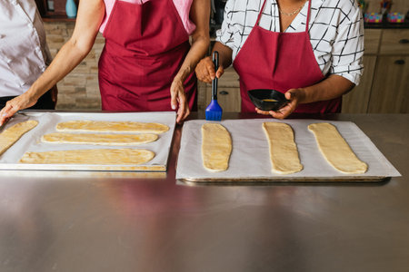 Bakers brushing dough with egg wash during cooking class