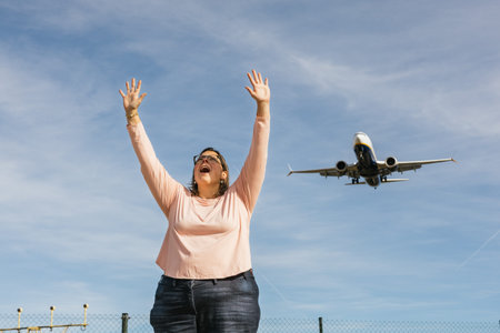 Woman celebrating joyful arrival watching airplane landing