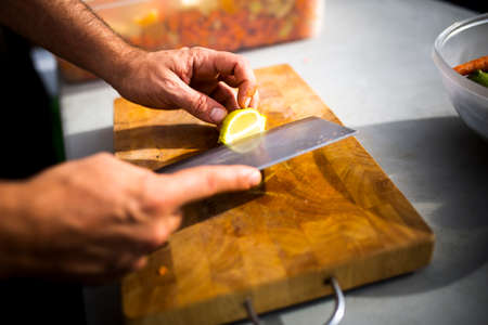 Closeup of hands chopping vegetables.