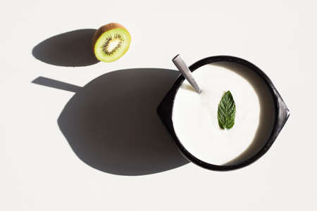 Wooden bowl of yogurt with a mint leafの写真素材