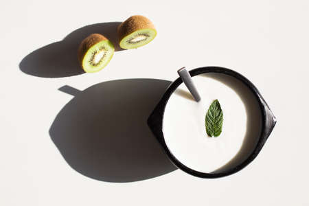 Wooden bowl of yogurt with a mint leafの写真素材