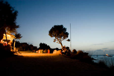Formentera, Spain -13 Aug 2008- Group of people having a drink in Cala Saona at duskのeditorial素材