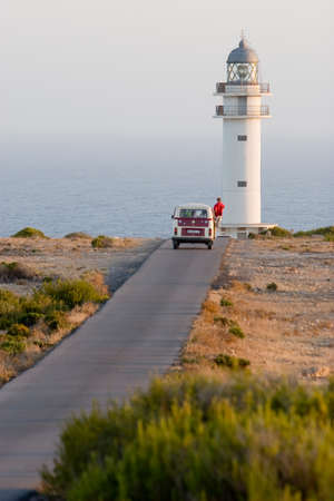 Formentera, Spain -12 Aug 2008- Man getting off his van while approaching to a lighthouseのeditorial素材