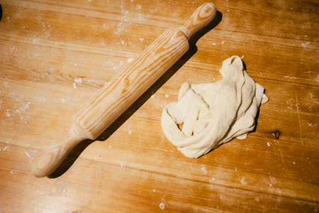 Bread dough and a roller on a wooden tableの写真素材