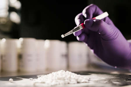 Hands of a scientist working with some pills