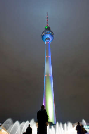 Berlin, Germany -19 Oct 2008- Couple in front of the tv tower Fernsehtur, in Alexanderplatz, watching the water fountain at nightのeditorial素材