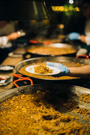 Chef serving fideuÃ  on a plate