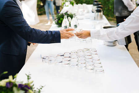 Waiter giving a cup of coffee to an atendee during a coffee break