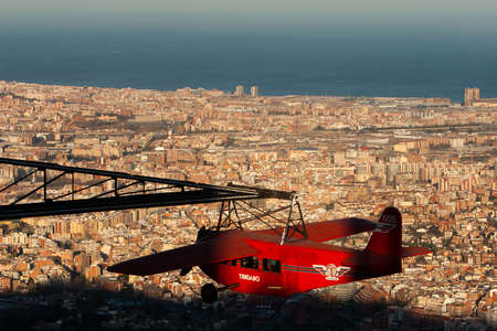 Barcelona, Catalonia. Spain -16 Mar 2020- El AviÃ³. Airplane carousel. A replica of the first aircraft to fly from Barcelona to Madrid in 1927, at the Tibidabo amusement park, and a view of Barcelona at the back.のeditorial素材