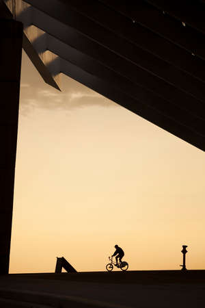 Barcelona, Catalonia, Spain -03 Apr 2011- Man riding a bike under a giant solar pannel at the Forum areaのeditorial素材
