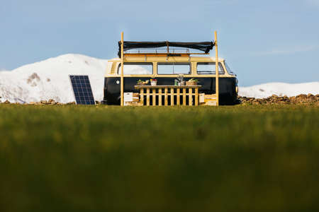 Food truck van on a green field with snow cropped mountains on the backgroundのeditorial素材