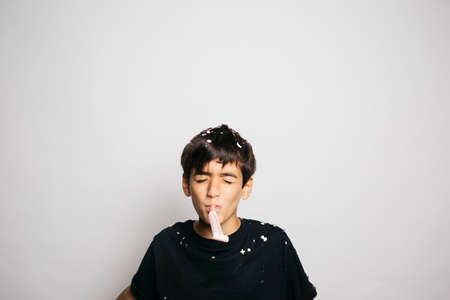 Portrait of a ten years old boy throwing confetti to the air