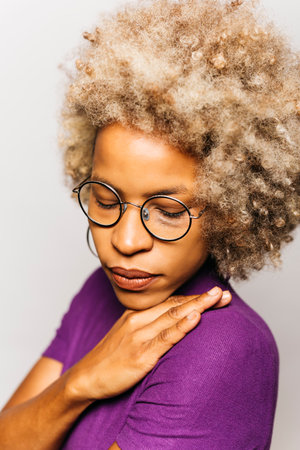 Portrait of Smiling black latin Young woman wearing purple clothes standing Against White Backgroundの写真素材