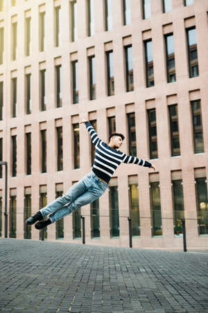 Young man jumping on the streetの写真素材
