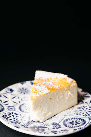Piece of homemade cheesecake over a black backgroundの写真素材