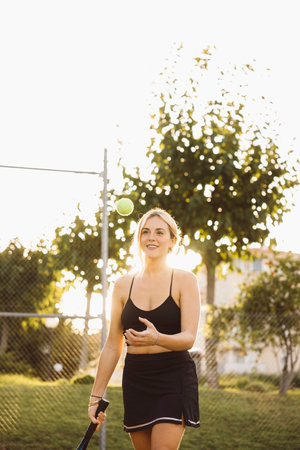 Sportswoman playing at the tennis court. Beautiful young woman on outdoor court and playing tennis match.の写真素材