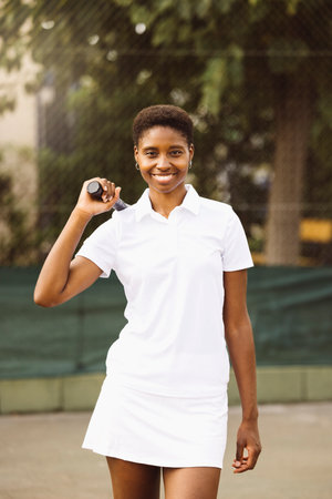 Portrait of a young beautiful women with tennis clothes and racket in a tennis court ready to play a game.の写真素材