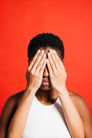 Portrait of young woman with her eyes covered by another woman's hands.の写真素材