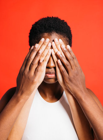 Portrait of young woman with her eyes covered by another woman's hands.の写真素材
