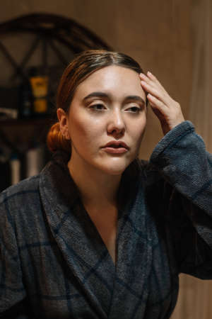 Girl touching her face wearing a bathrobeの写真素材