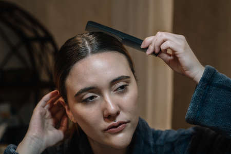 Girl brushing her hair wearing a bathrobeの写真素材