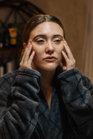 Girl pampering her face wearing a bathrobeの写真素材
