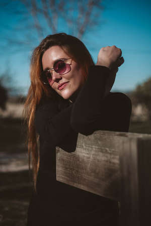 Girl posing and smiling while wear pink sunglasses