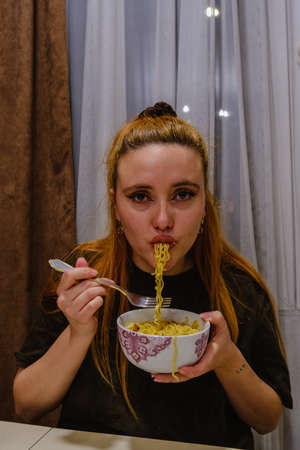 Girl eating asian noodles whit a forkの写真素材
