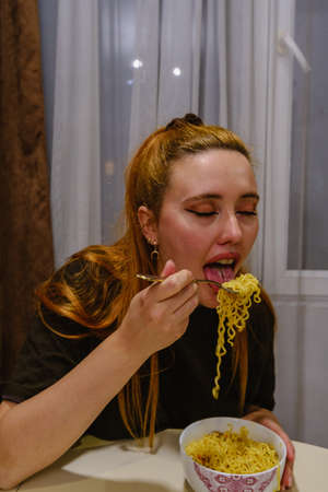 Girl eating asian noodles whit a forkの写真素材