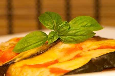 A dish of eggplant garnish with tomato and cheeseの写真素材