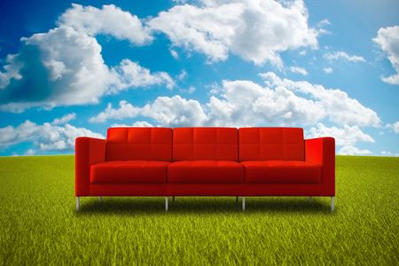 Comfortable red sofa in a green grass meadowの写真素材