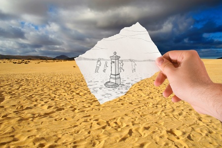  hand holds paper with sketch the fontanelle of water in the middle of the desertの写真素材