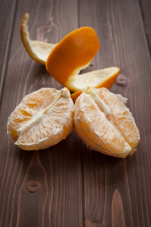 Orange fruit peeled on dark wood tableの写真素材