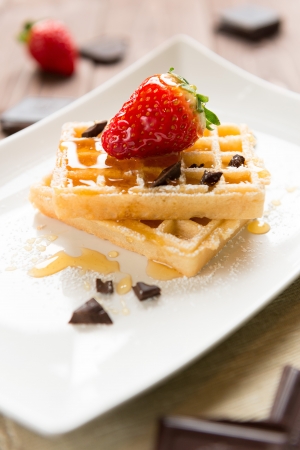 Waffel with strawberry decorated with honey and chocolateの写真素材
