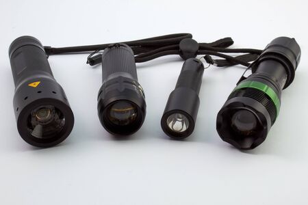 Different sized LED flashlights with black housing on a white background