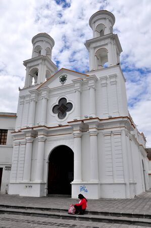 30/10/2009 Latacunga, Cotopaxi, Ecuador. A view of the Santo Domingo Church with an indigenous lady sitting on the steps.のeditorial素材