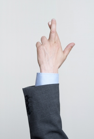 Man in a suit with his fingers crossedの写真素材
