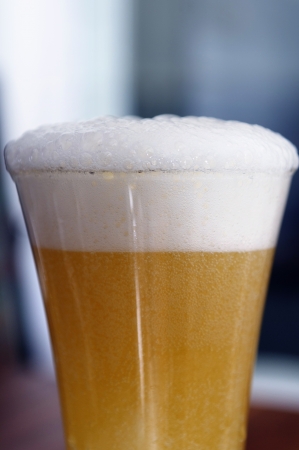 A glass of beer with foamの写真素材